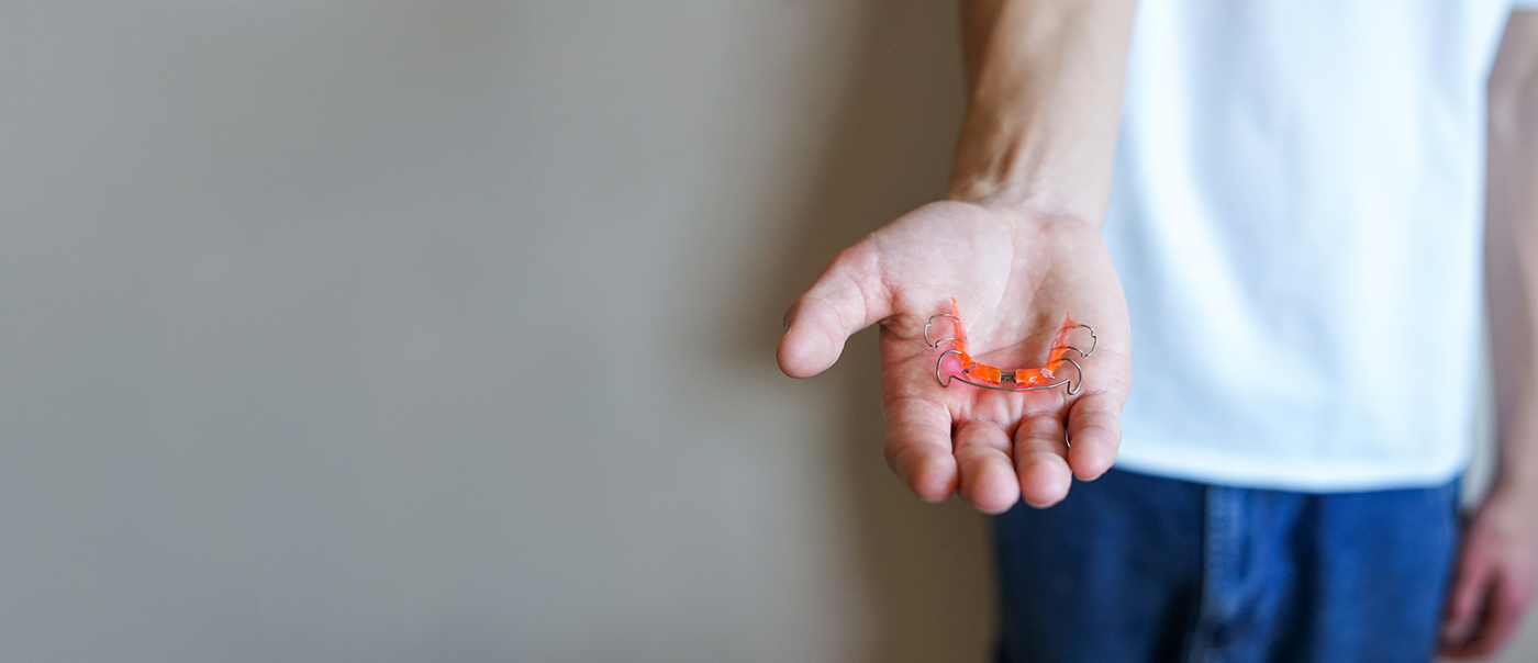 Hand holding a retainer in Round Rock