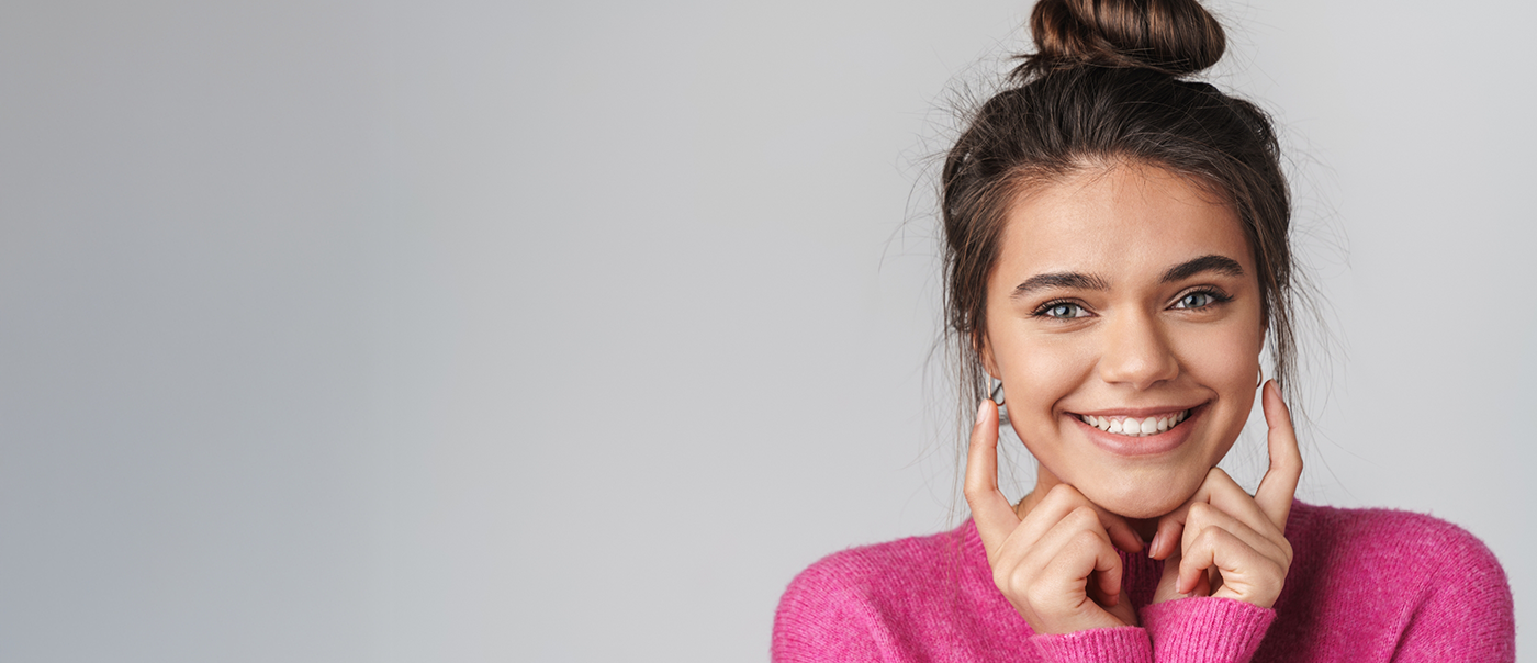Young woman pointing to her smile