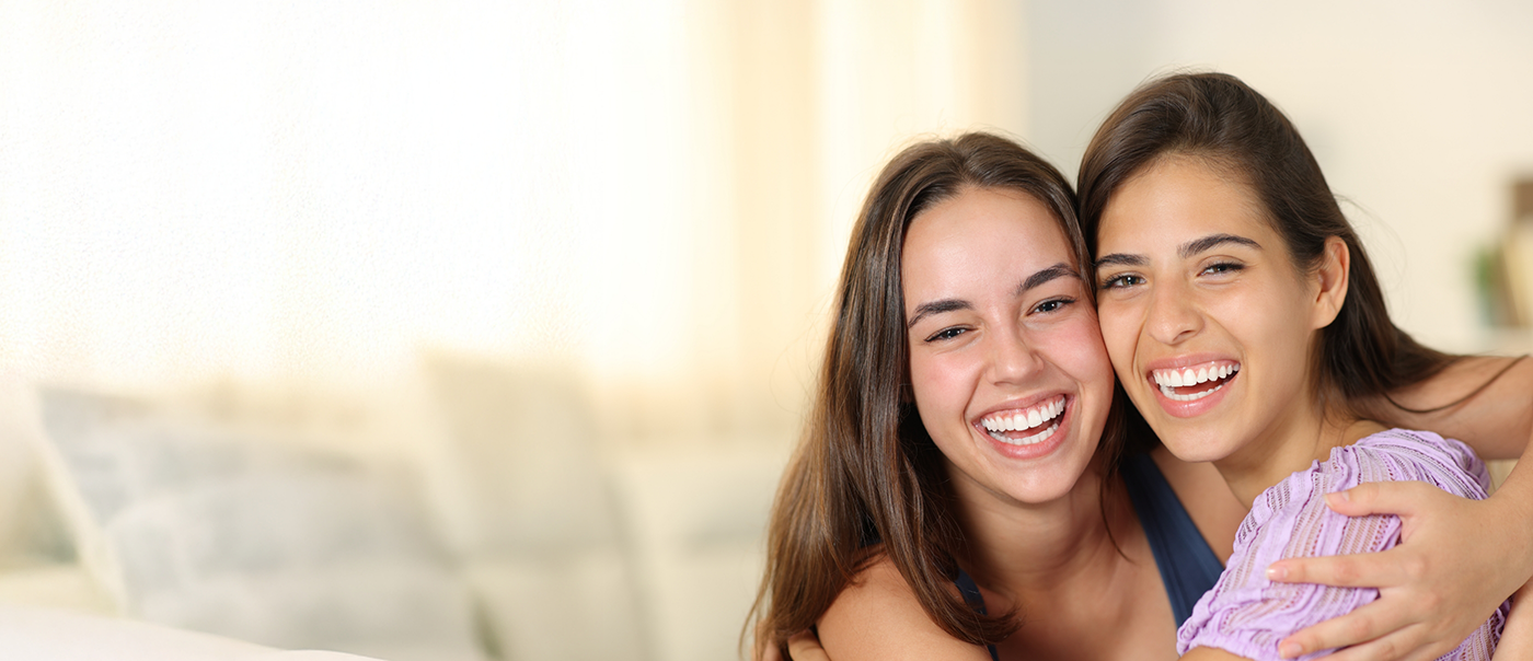 Mother and daughter smiling and hugging
