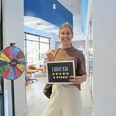 Blonde woman holding a sign reading I give them 5 stars